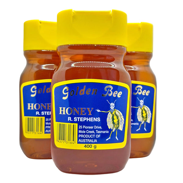 Three 400gms squeeze bottles of Golden Bee R. Stephens Honey arranged together on a white surface, showing the amber honey through clear jars with bright yellow lids and blue labels.